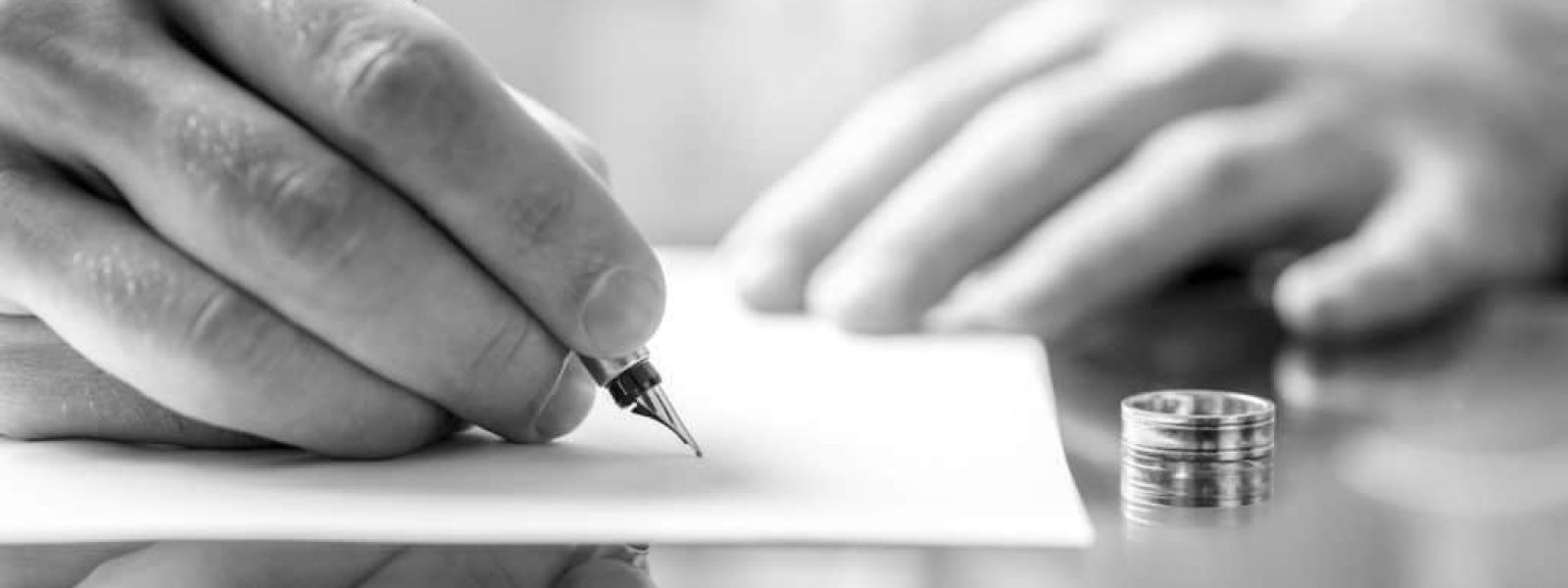 Closeup of a man signing  divorce papers.